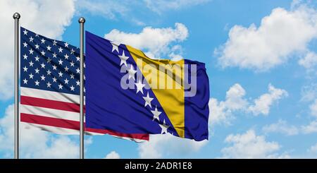 United States and Bosnia Herzegovina flag waving in the wind against white cloudy blue sky together. Diplomacy concept, international relations. Stock Photo