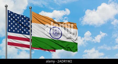 United States and India flag waving in the wind against white cloudy blue sky together. Diplomacy concept, international relations. Stock Photo