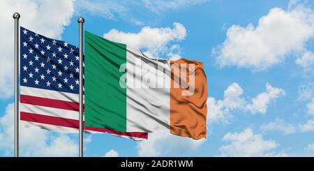 United States and Ireland flag waving in the wind against white cloudy blue sky together. Diplomacy concept, international relations. Stock Photo