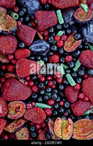 Frozen berries in grocery store shot close-up, blurred background. Multicolored mix of strawberries, plums, currants. Stock Photo