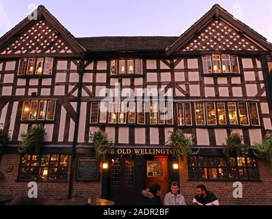 The Old Wellington,half timbered,pub from 1552,scheduled ancient monument,4 Cathedral Gates, Manchester. At dusk, winter time. Stock Photo