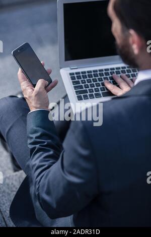 Rear view of a professiaonal businessman using his laptop Stock Photo