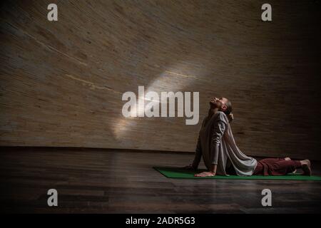 Woman stretching on the yoga mat with her eyes closed Stock Photo