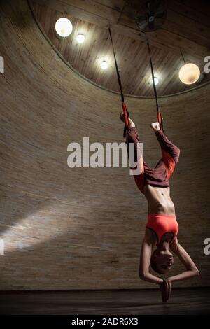 Woman practicing aerial yoga with special straps Stock Photo