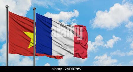 Vietnam and France flag waving in the wind against white cloudy blue sky together. Diplomacy concept, international relations. Stock Photo