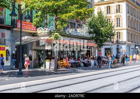 French locals and tourists enjoy an afternoon meal at a sidewalk cafe in Nice, France. Stock Photo