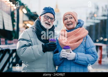 Happy aged couple being on the winter fair and smiling Stock Photo
