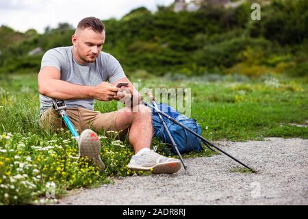 PLeasant man with prosthesis using his smartphone Stock Photo