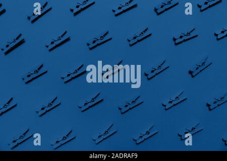 Blue clothes pins on the blue background. Monochrome concept. Horizontal Stock Photo