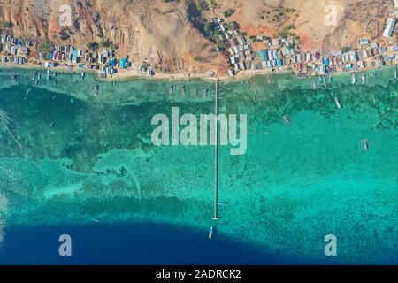 Aerial and top view the beautiful blue ocean and fisherman village at the remote island called Papagarang located in Komodo National Park, Indonesia. Stock Photo