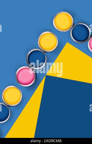 Renovation concept. Blue and yellow background with group of colored paint cans. Flat lay, top view, copy space. Stock Photo