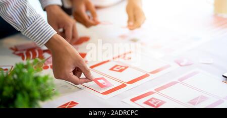 Cropped shot of professional UX web development team working on their smartphone project together Stock Photo
