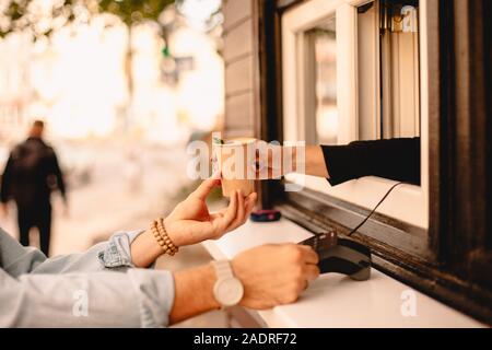 Customer making payment with credit card buying coffee on city street Stock Photo