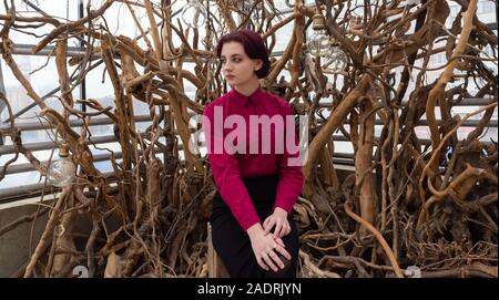 girl in a red shirt and skirt against the white background of trees Stock Photo