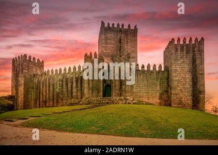 View of Romanesque Guimaraes castle with dramatic sunset sky in Northern Portugal Stock Photo