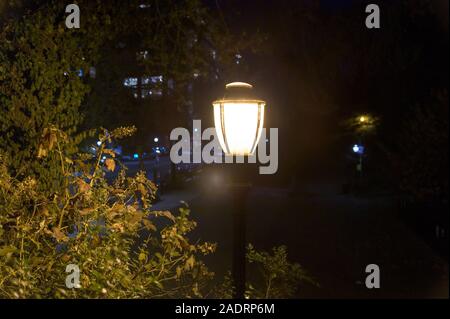 Old-fashioned street lamp in a public park at night, on Manhattan's Upper East Side, New York City Stock Photo