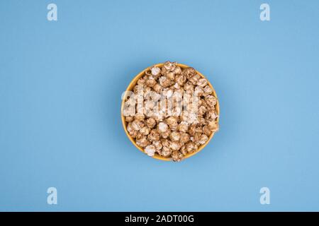 Caramel sweet popcorn bowl isolated on pink background top view. Frame composition with copy space. Stock Photo