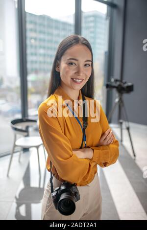 Dark-haired young cute reporter standing in the studio Stock Photo