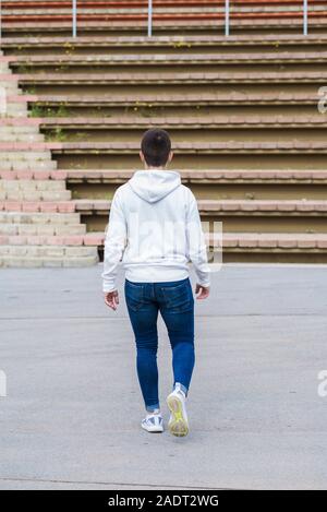 Back view of a young male walking away outdoors Stock Photo