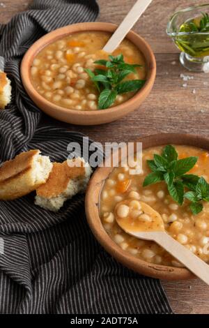 Served traditional hot beans soup with corn bread, garlic and olive oil. Vegetarian healthy dish, vegan food Stock Photo