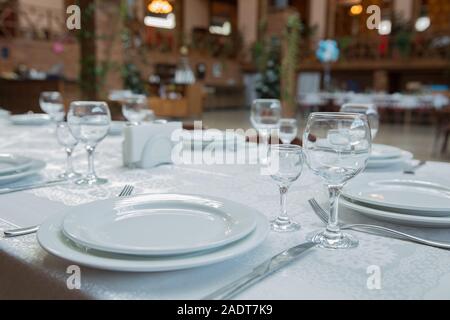 Tables set for meal . fork, knife . empty glasses and plates on the table in the restaurant . Stock Photo