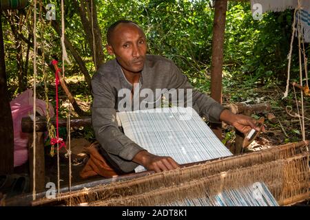 Ethiopia, Amhara Region, Bahir Dar, Lake Tana, Zege Peninsula, man weaving cloth for souvenir stall Stock Photo