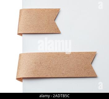 Paper ribbon bookmark or label tags. Craft paper on a white background. Stock Photo