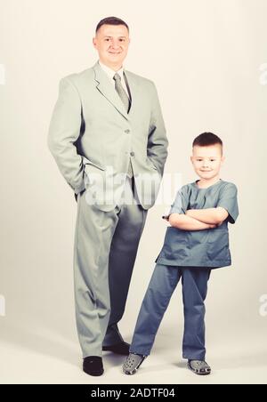 business partner. small boy doctor with dad businessman. childhood. trust and values. fathers day. family day. father and son in business suit. male fashion. happy child with father. We are family. Stock Photo