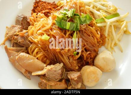 dried thin rice noodle topping braised pork dressing cayenne pepper on dish Stock Photo