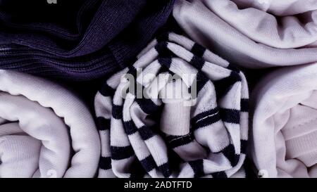 Vertical storage of clothing in rolls. Minimalism color scheme T-shirts rolled for saving luggage space. Close up. Front view. Stock Photo