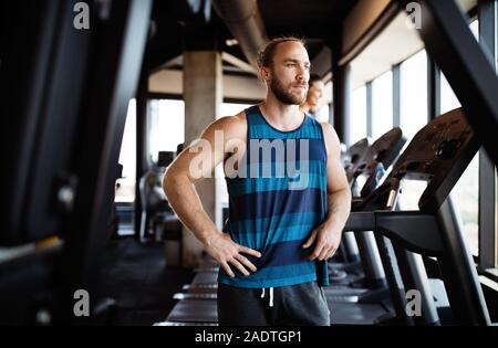 Group of young people running on treadmills in modern sport gym Stock Photo