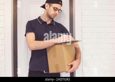 Courier delivering package client signing document Stock Photo