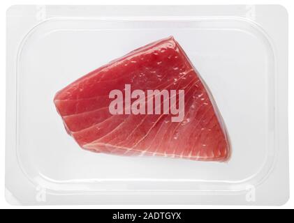 Fresh healthy tuna steak vacuum packed in plastic over a white background in a close up view in a food and nutrition concept Stock Photo