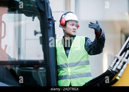 civil engineer standing in front of an  excavator Stock Photo
