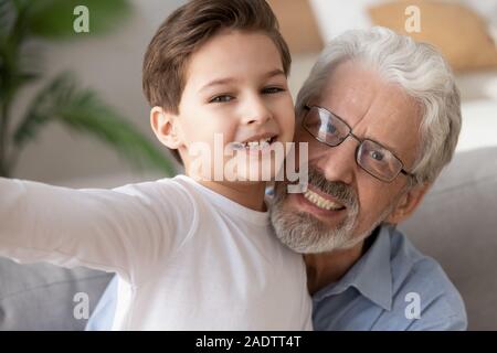 Portrait elderly grandfather and grandson taking selfie together webcam view Stock Photo