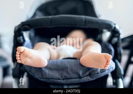 Cute adorable caucasian blond toddler bou sleeping in stroller at daytime. Children healthcare and happy childhood concept Stock Photo