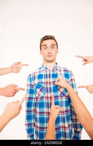 Portrait of a surprised handsome young man being criticized by others Stock Photo