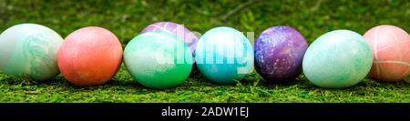 Panorama, colorful dyed easter eggs in a line on green meadow or moss Stock Photo