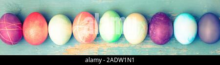 Topview, colorful dyed easter eggs on blue vintage wooden table, panorama Stock Photo