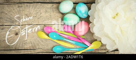 Pastel colored easter eggs, spoons and paper flower, german text schoene ostern, which means happy easter Stock Photo