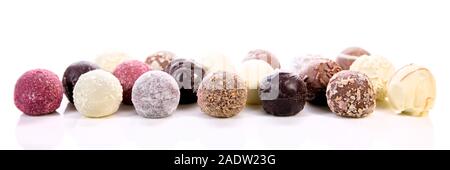 Variation of different chocolate truffles or pralines, white background, panorama