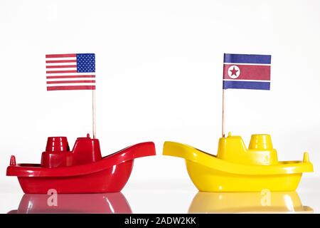 ships with the flags of united states and north korea in front of white background Stock Photo