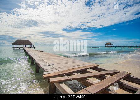 Wooden Footbridge into beautiful Caribbean Sea with perfect turquoise water and incredible sky Stock Photo