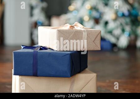 Christmas golden gift decorations. Multi-colored gift boxes on the background of a Christmas tree and multi-colored bokeh. New year eve Stock Photo