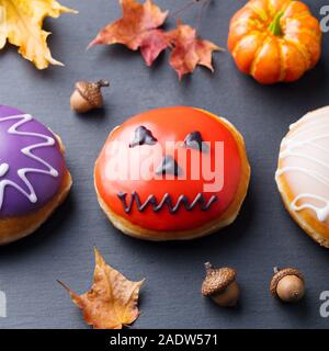 Donuts with Halloween decoration, icing on black slate background. Top view. Close up Stock Photo