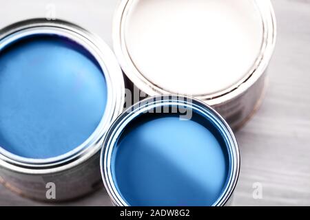 Several opened cans with paint inside. Blue and white colors of paint. Close up. Stock Photo