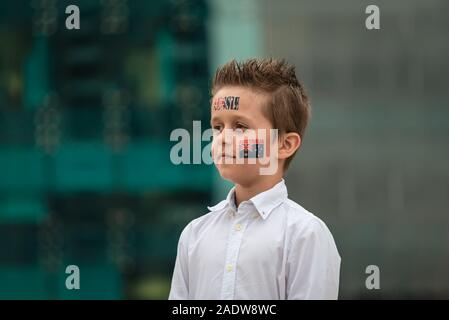 Portrait of proud Aussie boy with flag themed tattoos standing during Australian National Anthem during Australia Day celebration Stock Photo