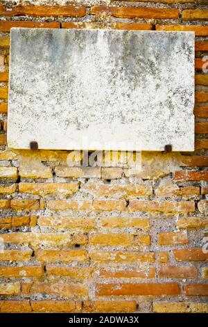 Vintage marble sign on brick wall, patina on surface Stock Photo