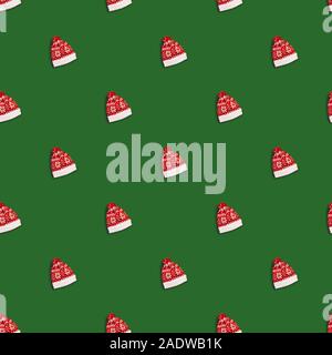 Christmas red hat with deers on green background, seamless pattern. Santa Claus hat, flat lay Stock Photo