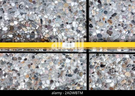 Craftsman controls whether freshly laid floor tiles are in the water, spirit level on washed concrete slabs Stock Photo
